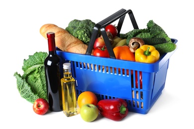 Shopping basket and grocery products on white background