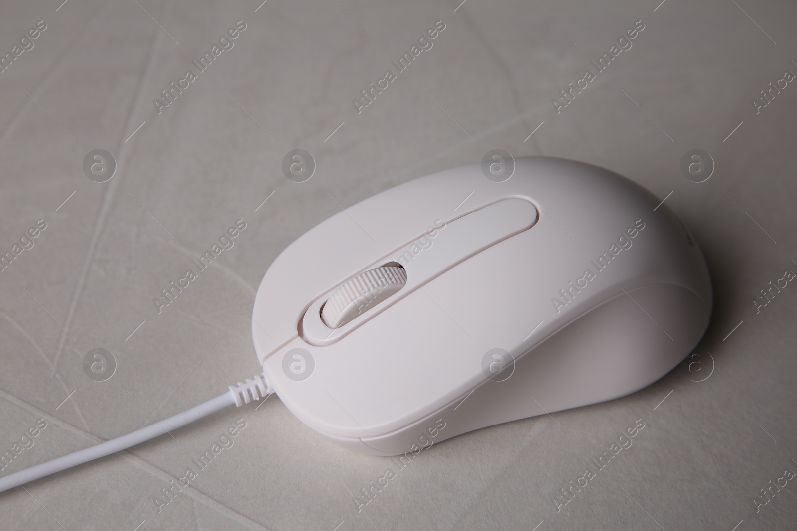 Photo of One wired mouse on grey textured table, closeup