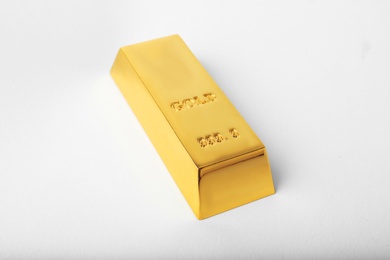 Photo of Precious shiny gold bar on white background