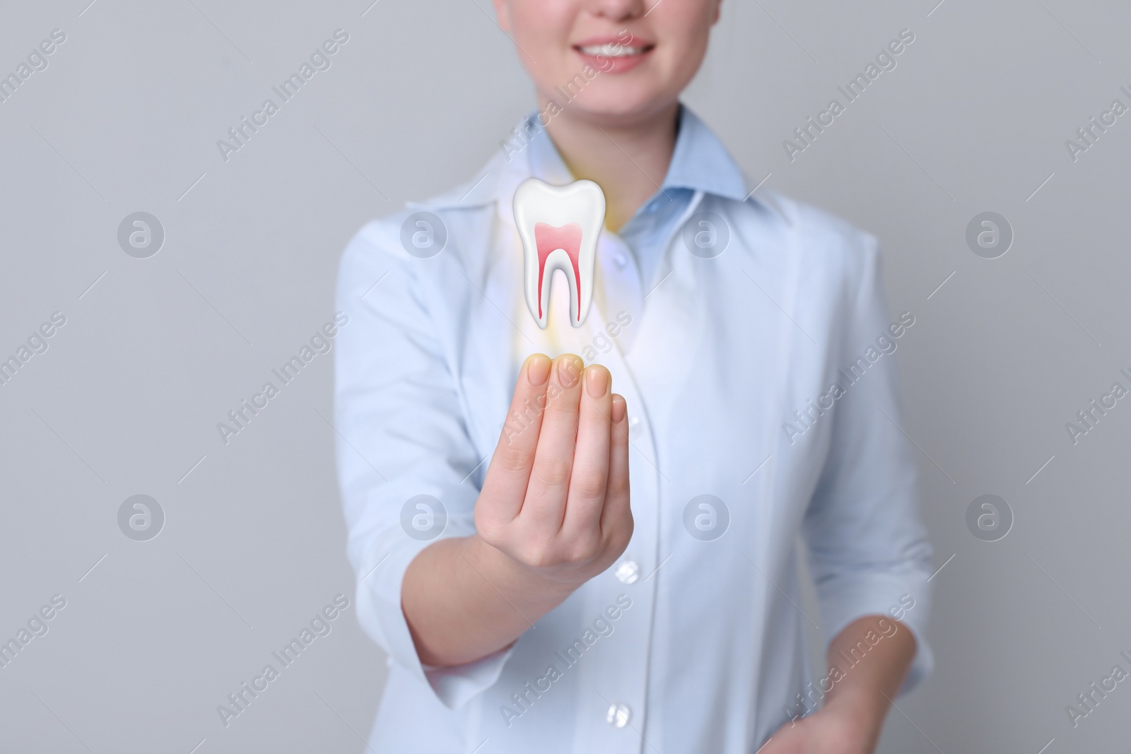 Image of Dentist showing virtual model of tooth on light grey background, closeup