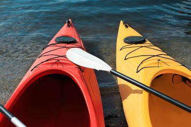 Modern kayaks with paddle on river, closeup. Summer camp activity
