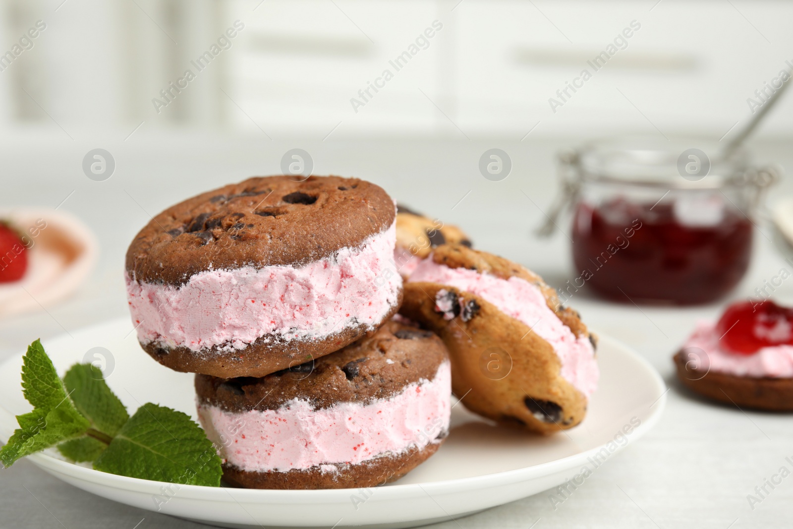 Photo of Plate with sweet delicious ice cream cookie sandwiches on table, space for text