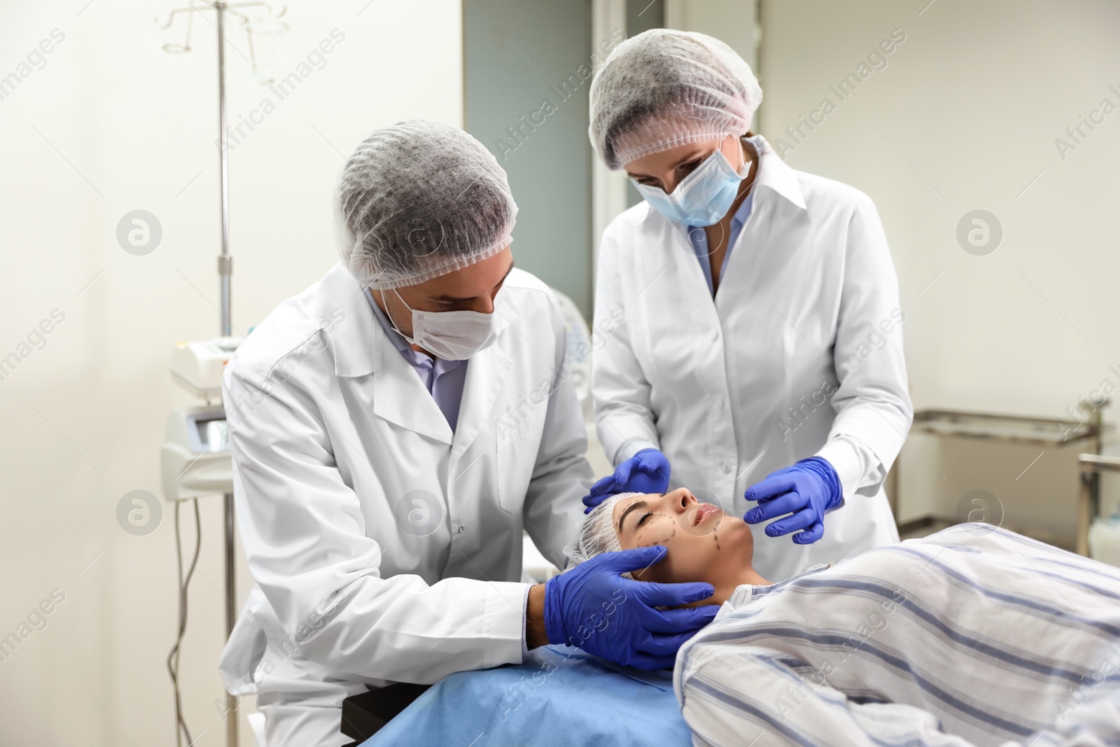 Photo of Doctor and nurse preparing female patient for cosmetic surgery in clinic