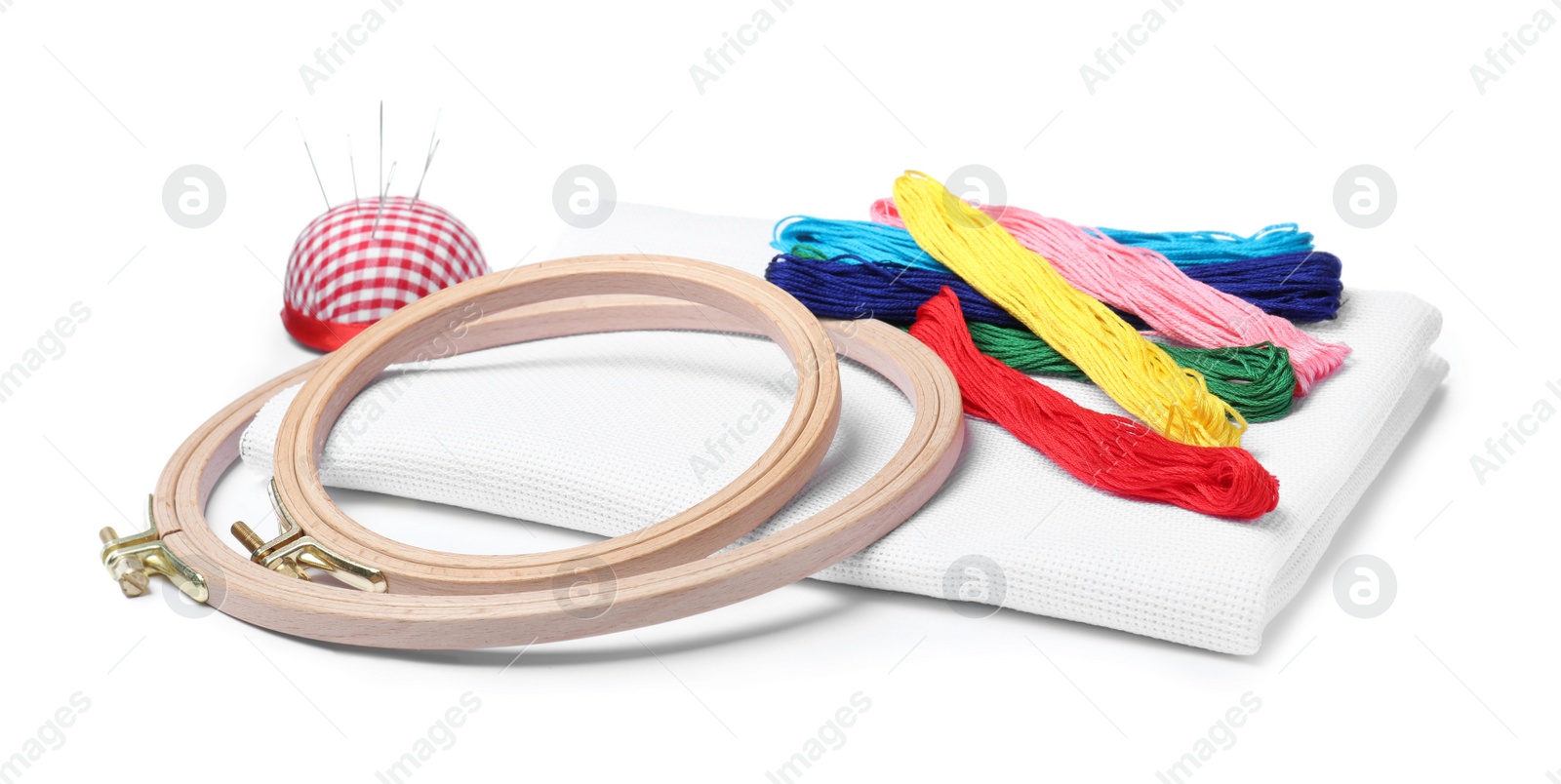 Photo of Colorful threads and different embroidery accessories on white background