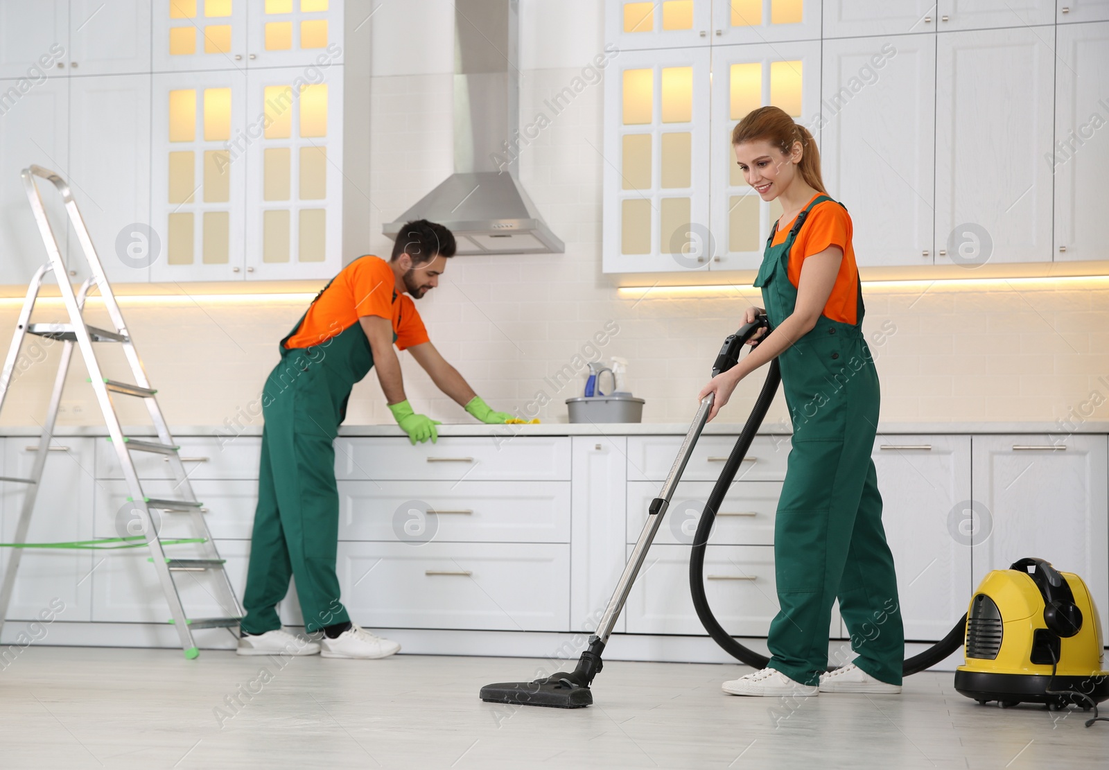 Photo of Team of professional janitors cleaning modern kitchen