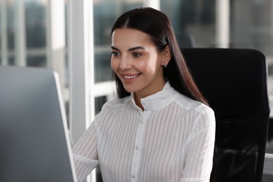 Photo of Happy woman using modern computer in office