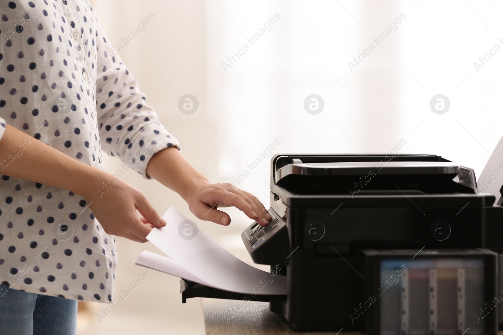 Photo of Employee using modern printer in office, closeup