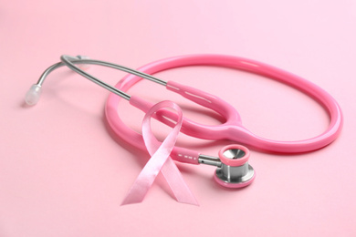 Photo of Pink ribbon and stethoscope on color background. Breast cancer concept