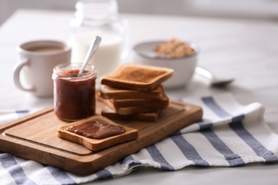 Photo of Delicious breakfast with toasts and jam on table in kitchen