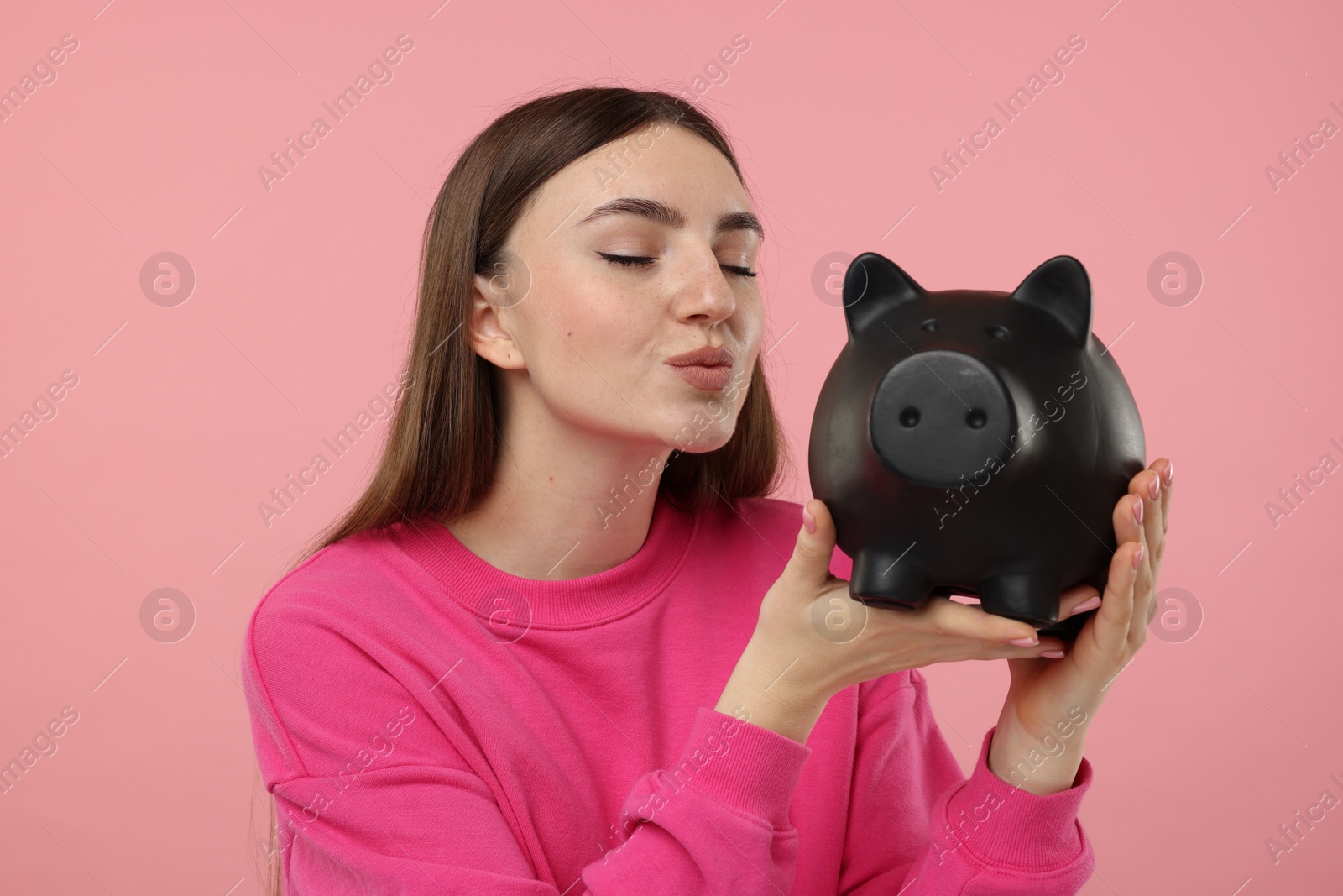 Photo of Woman with piggy bank on pink background