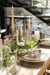 Photo of Elegant table setting with beautiful floral decor and burning candle