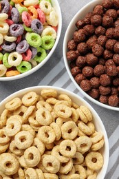 Photo of Different delicious breakfast cereals on kitchen towel, above view