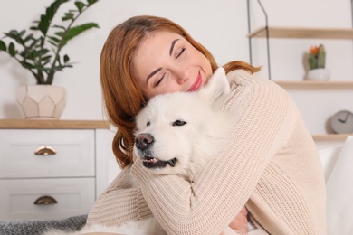 Photo of Beautiful woman with her dog sitting on sofa at home
