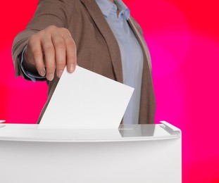 Image of Woman putting her vote into ballot box on color background, closeup