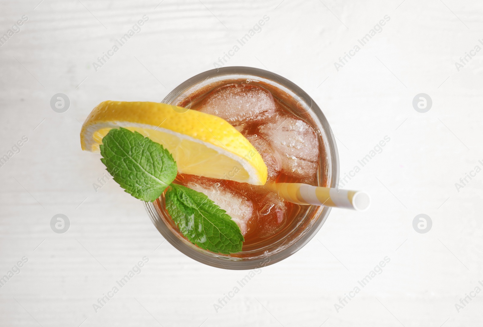 Photo of Delicious iced tea with lemon and mint on white wooden table, top view