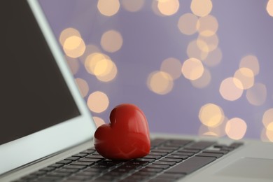 Photo of Red decorative heart on laptop, closeup view. Online dating