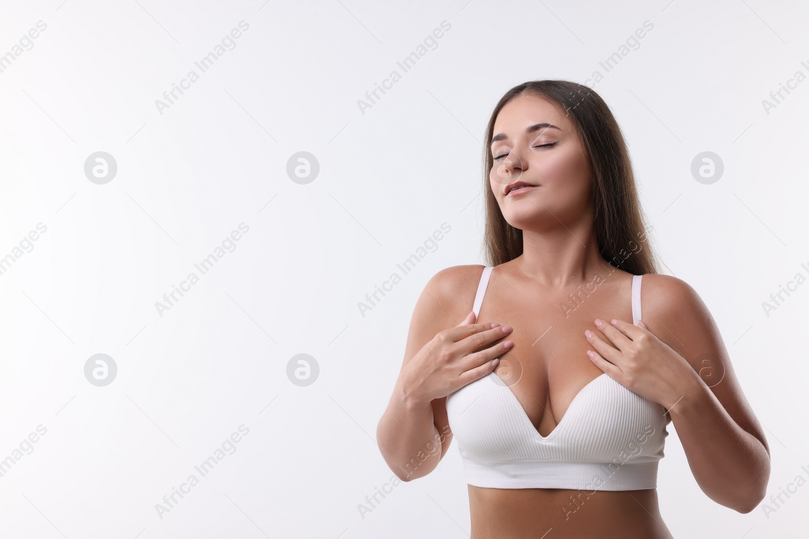 Photo of Portrait of young woman with beautiful breast on white background. Space for text
