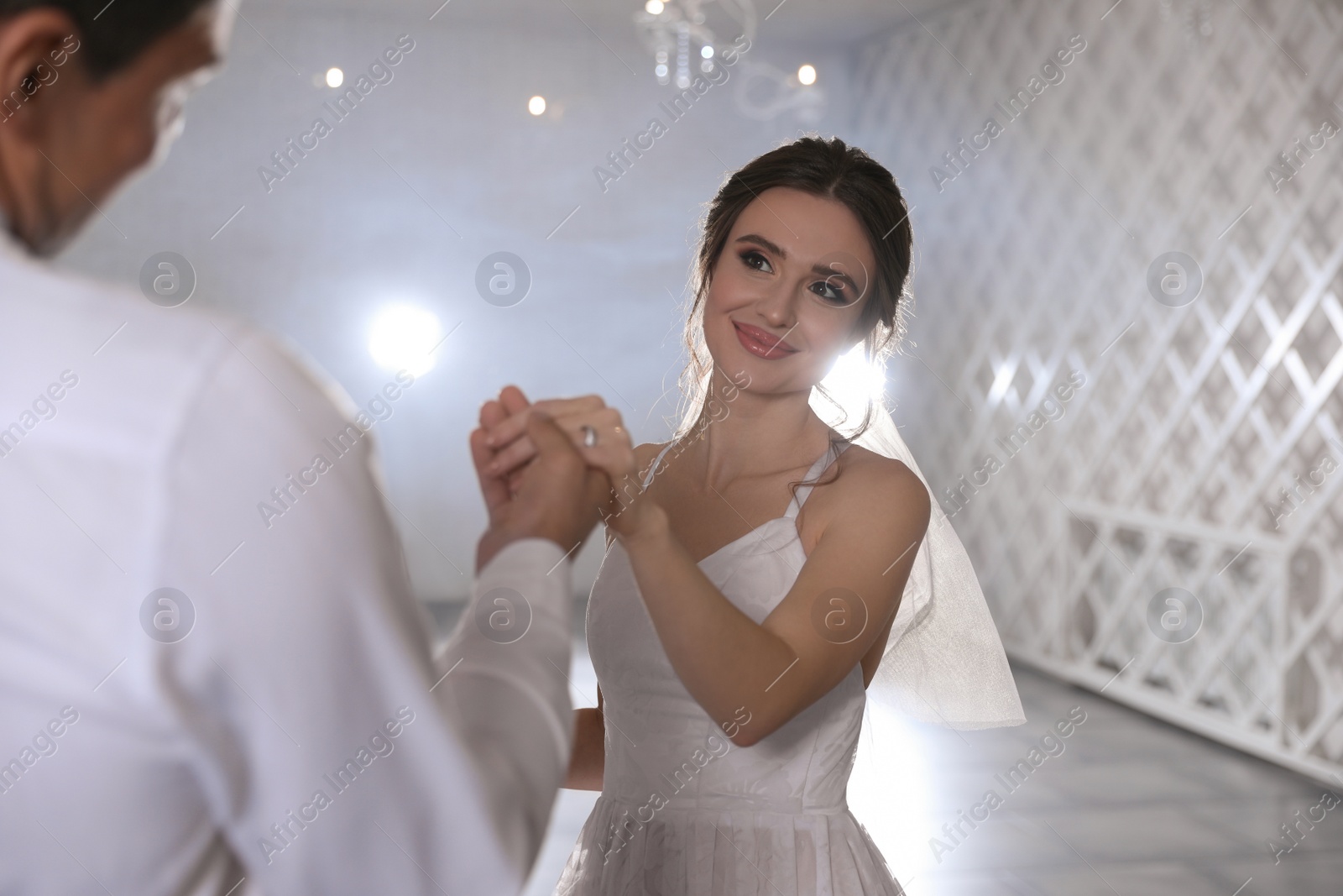 Photo of Happy newlywed couple dancing together in festive hall