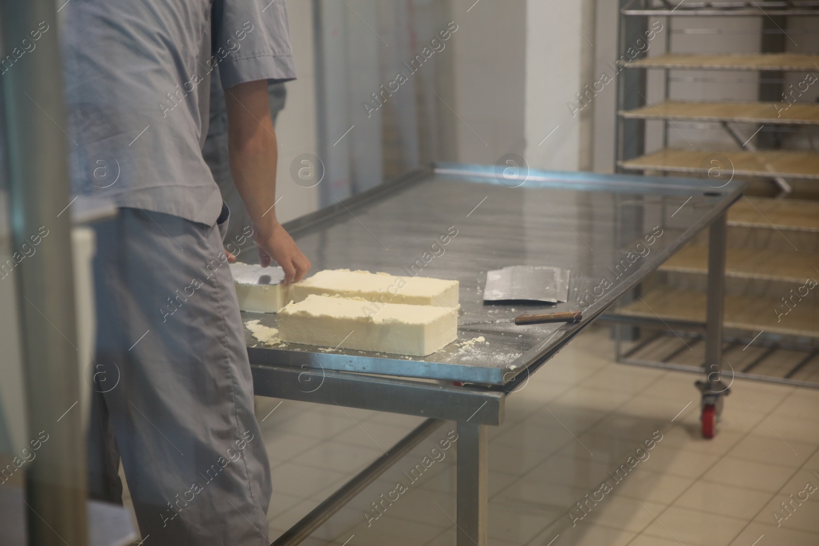 Photo of Worker with fresh cheese at modern factory, closeup