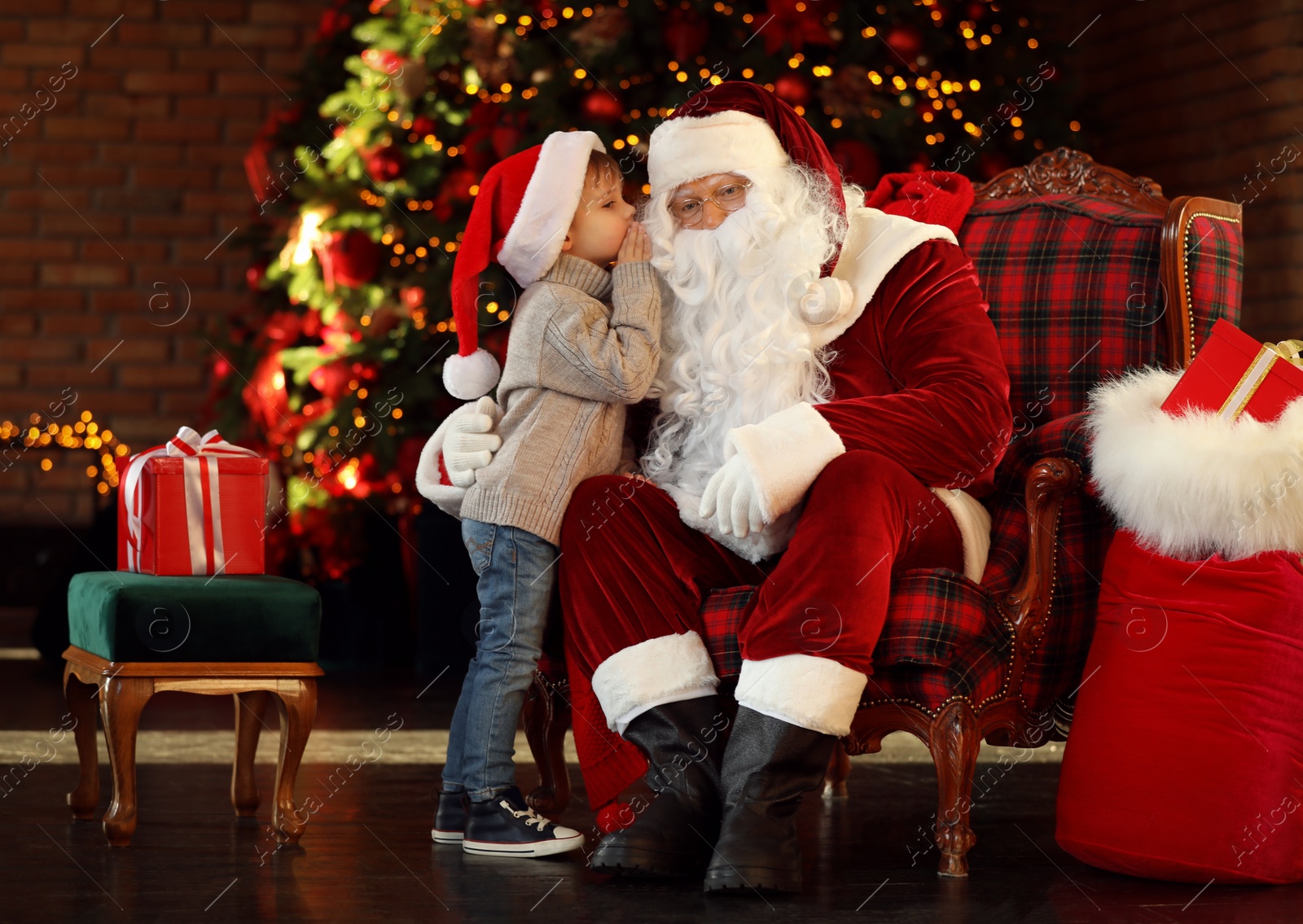 Photo of Santa Claus and little boy near Christmas tree indoors