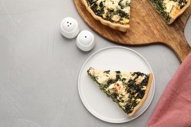 Photo of Delicious homemade spinach quiche on light gray table, flat lay. Space for text