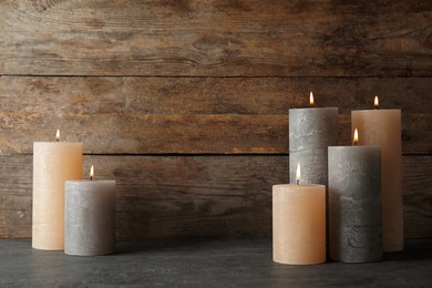 Photo of Alight wax candles on table. Space for text