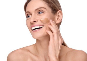 Woman with swatch of foundation on face against white background