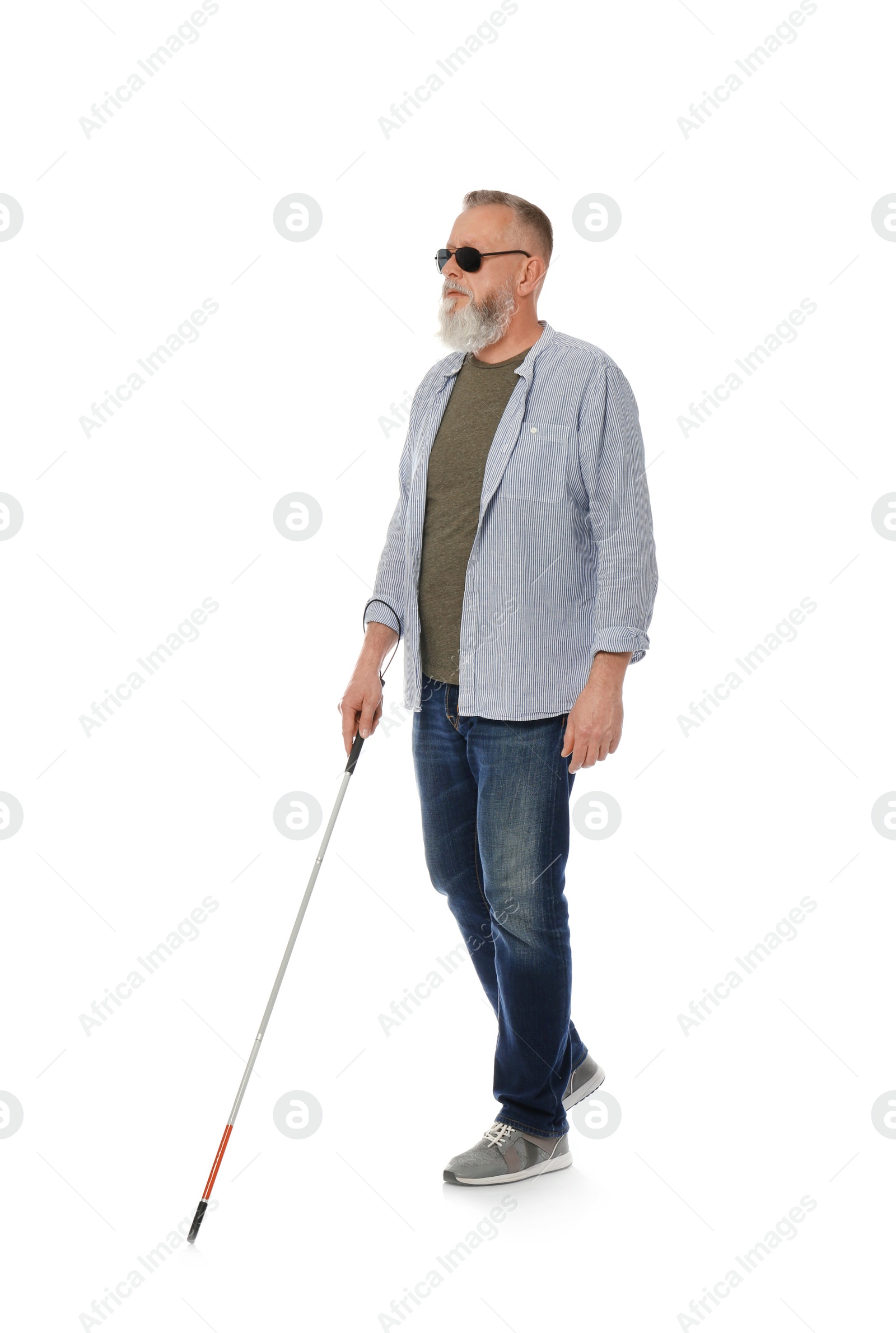 Photo of Mature blind person with long cane walking on white background