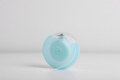 Photo of Container with dental floss on white background