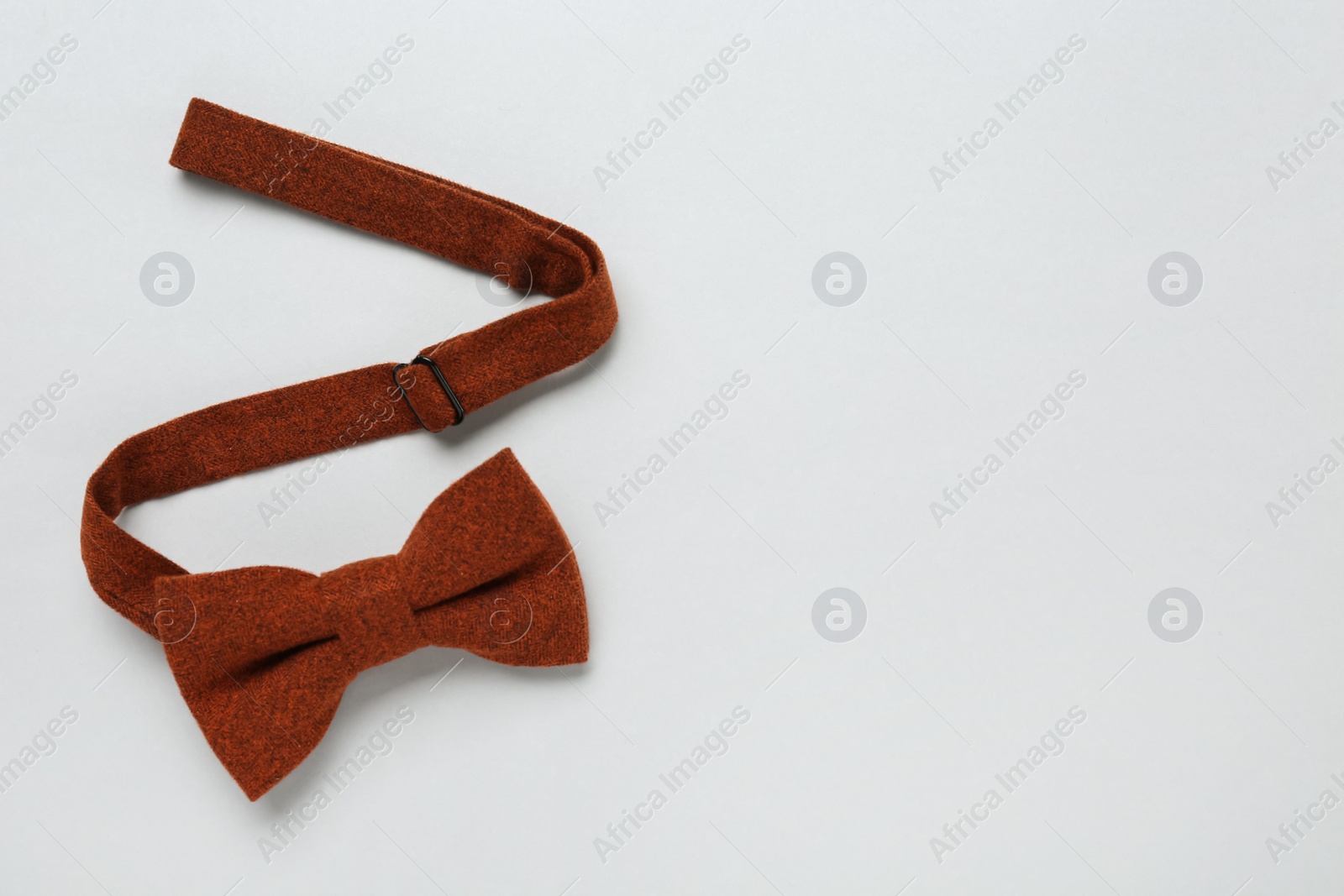 Photo of Stylish terracotta bow tie on white background, above view