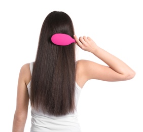 Photo of Back view of young woman with hair brush on white background