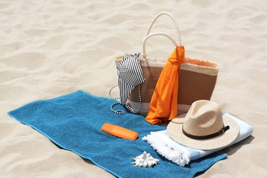 Blue towel, bag and accessories on sandy beach