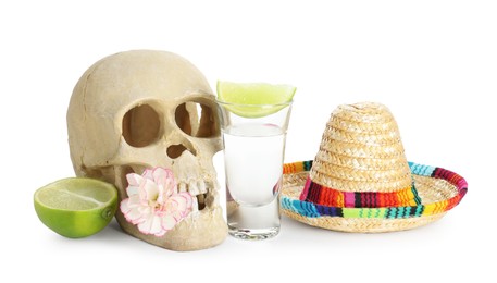 Photo of Mexican sombrero hat, human scull with flower, tequila and lime isolated on white