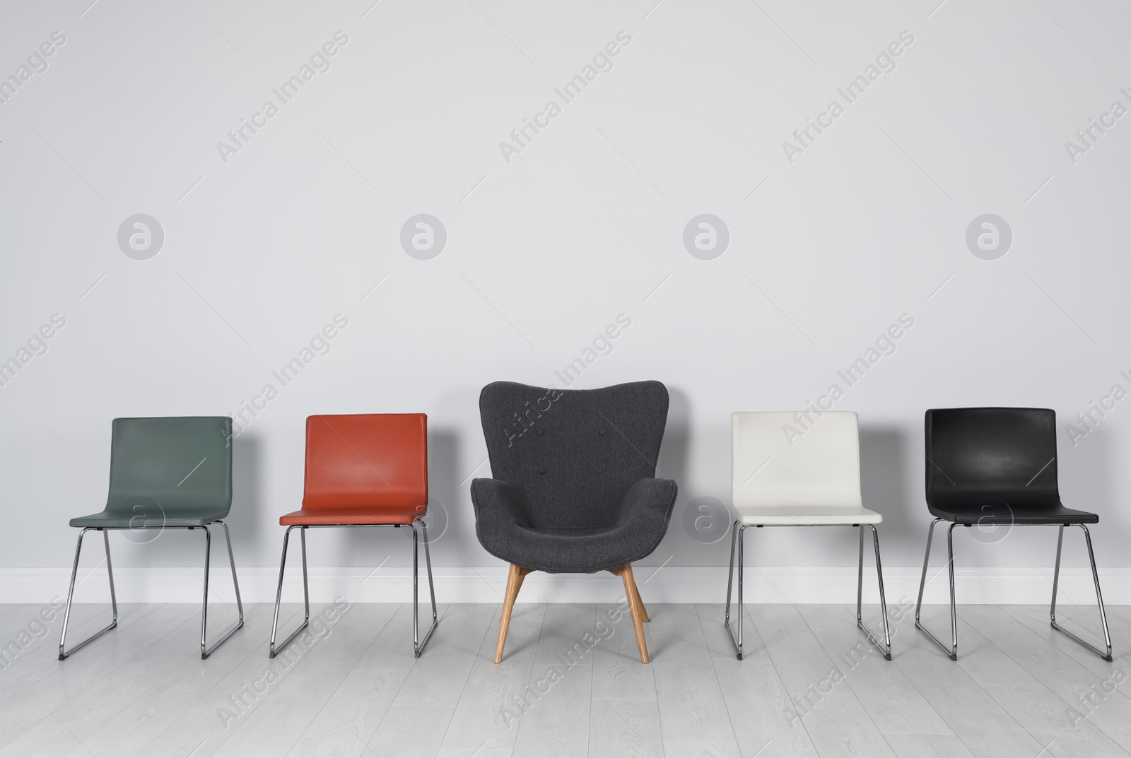 Photo of Comfortable armchair and chairs indoors. Interior decor elements