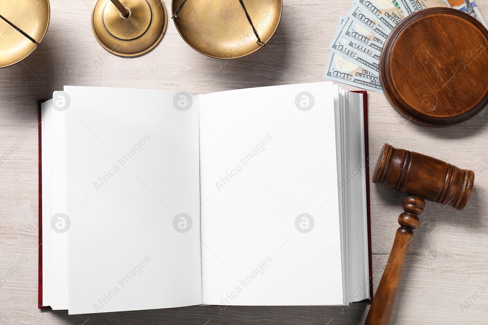 Photo of Tax law. Open book, gavel, dollar banknotes and scales on wooden table, flat lay