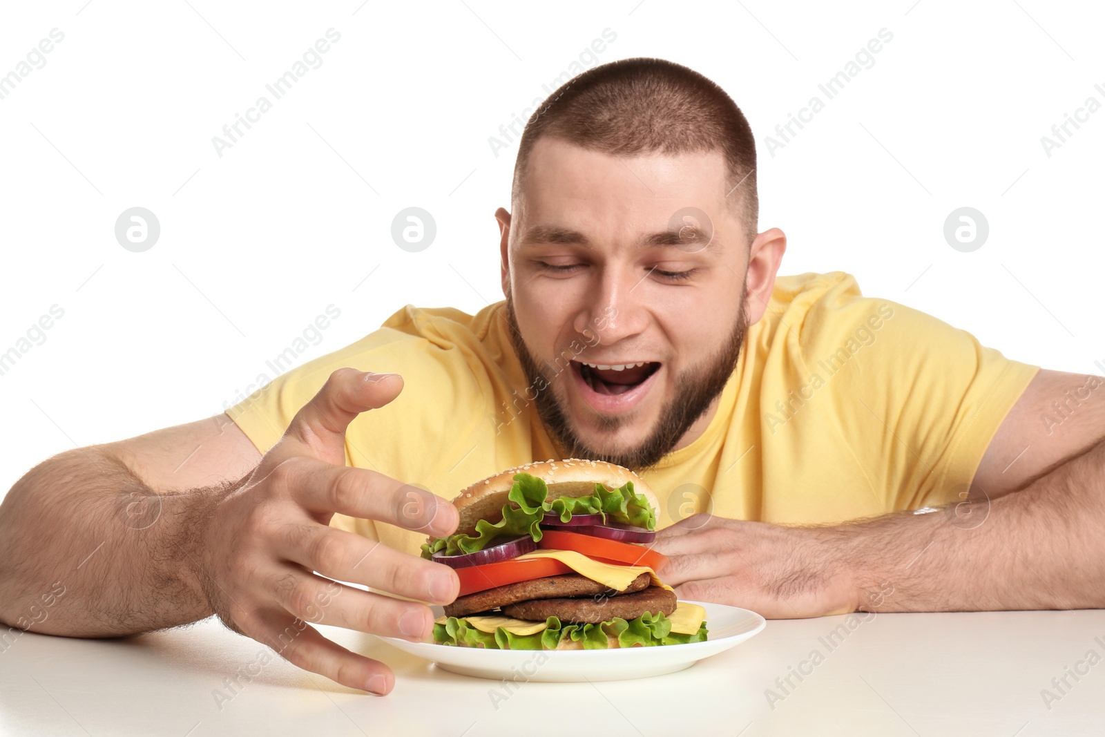 Photo of Young hungry man and tasty burger on white background