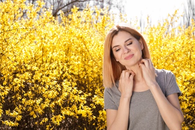 Photo of Woman suffering from seasonal allergy outdoors, space for text