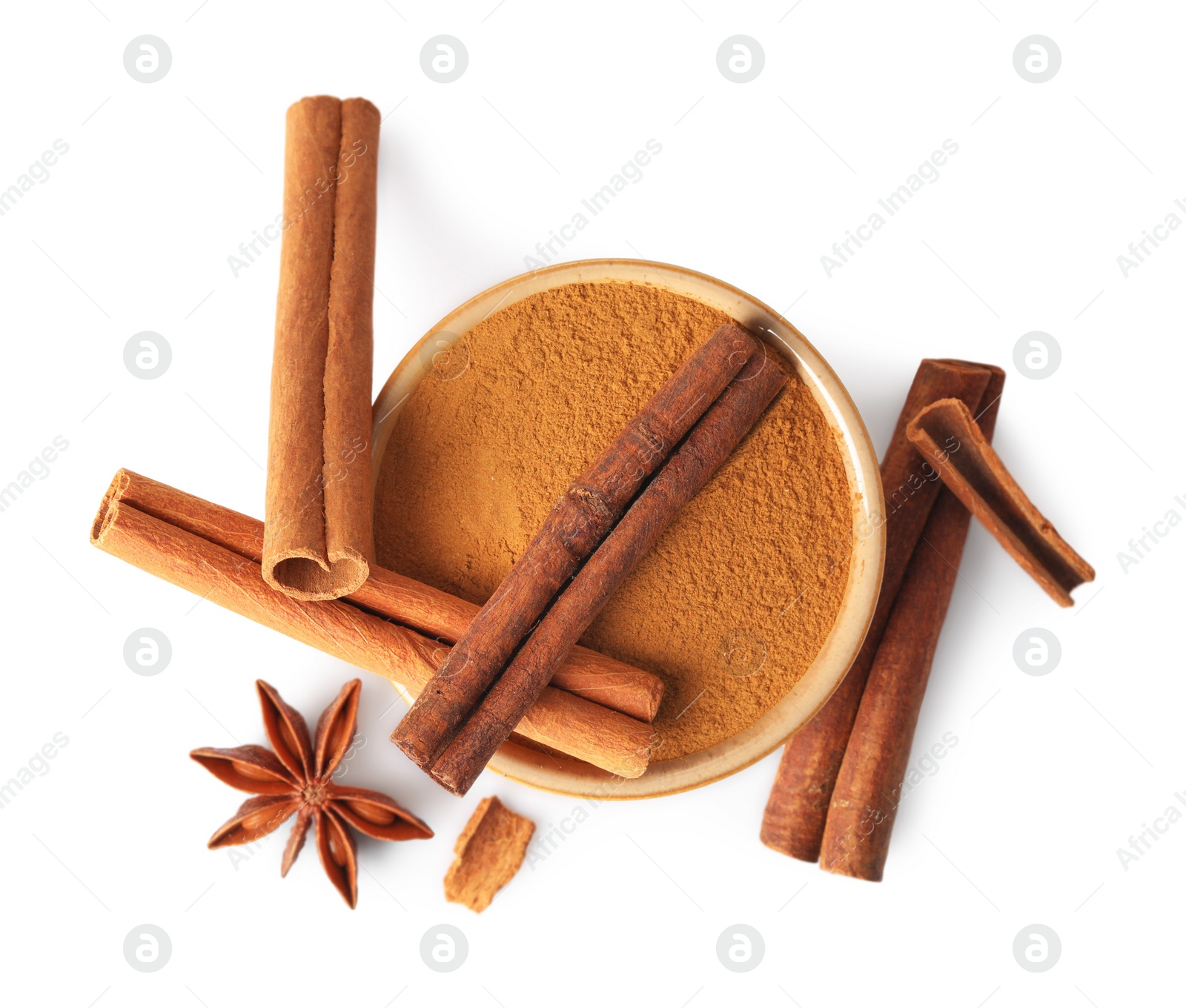 Photo of Dry aromatic cinnamon sticks, powder and anise star isolated on white, top view