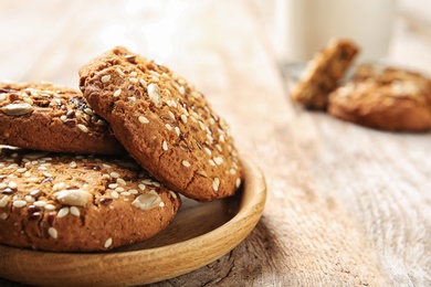 Plate with grain cereal cookies on wooden table, closeup. Healthy snack