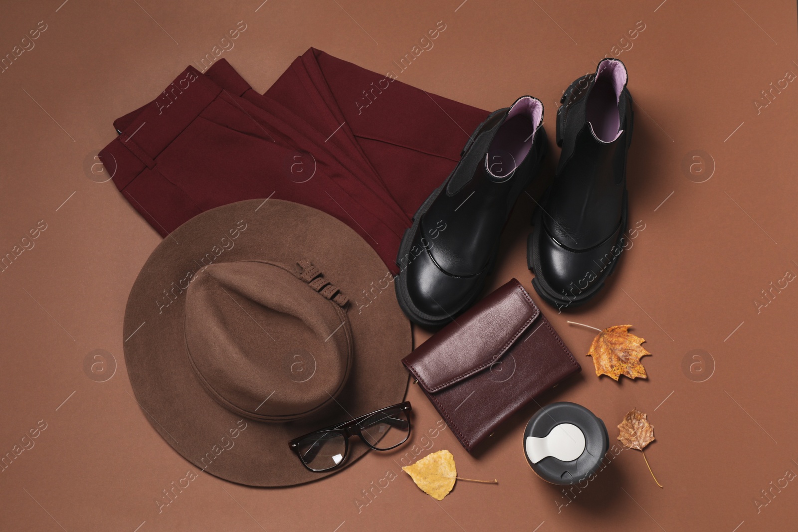 Photo of Flat lay composition with stylish hat on brown background