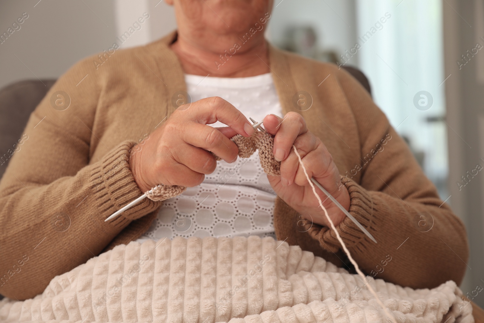 Photo of Elderly woman knitting at home, closeup. Creative hobby