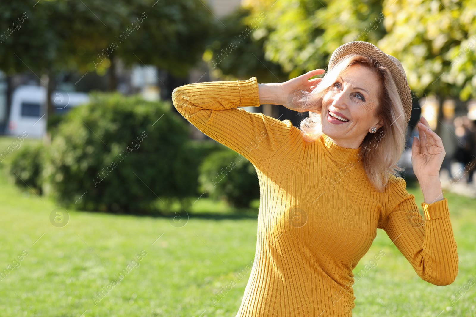 Photo of Portrait of happy mature woman with hat in park on sunny day