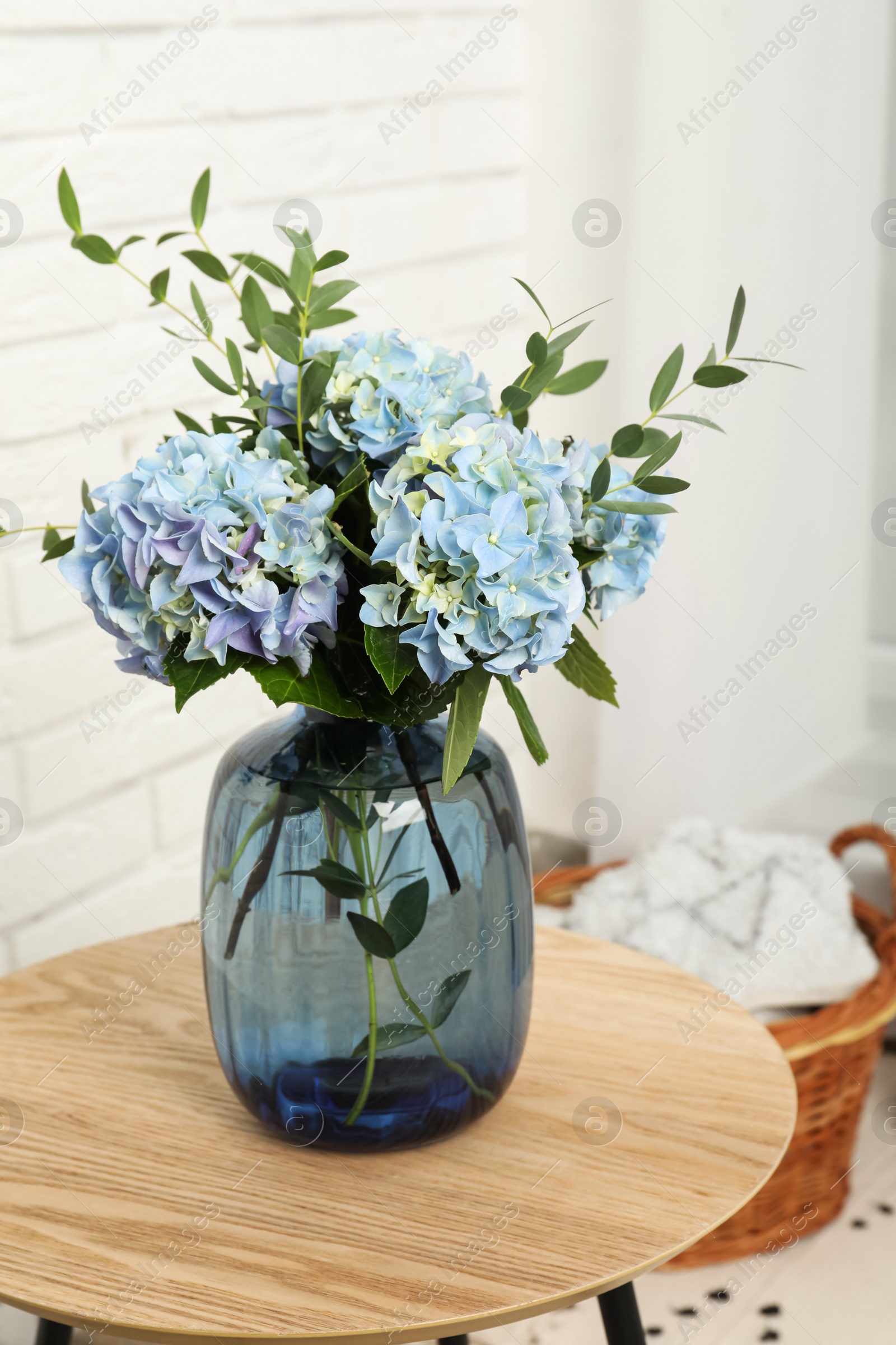 Photo of Beautiful blue hortensia flowers in vase on table indoors