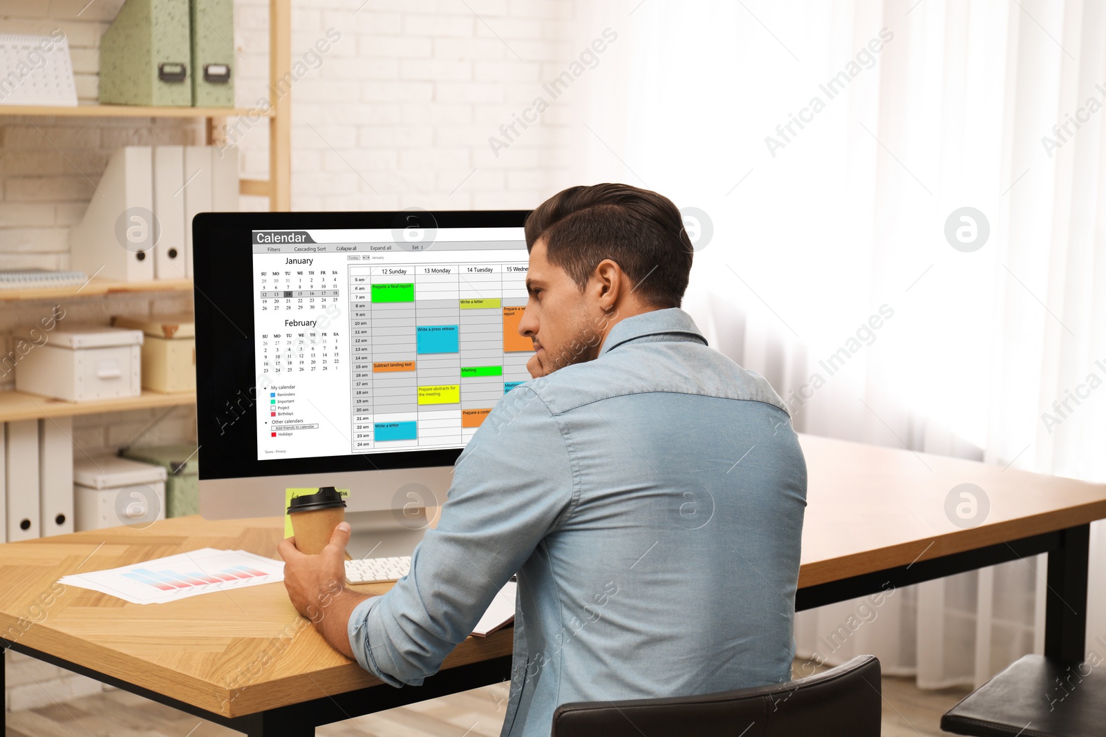 Photo of Handsome man using calendar app on computer in office