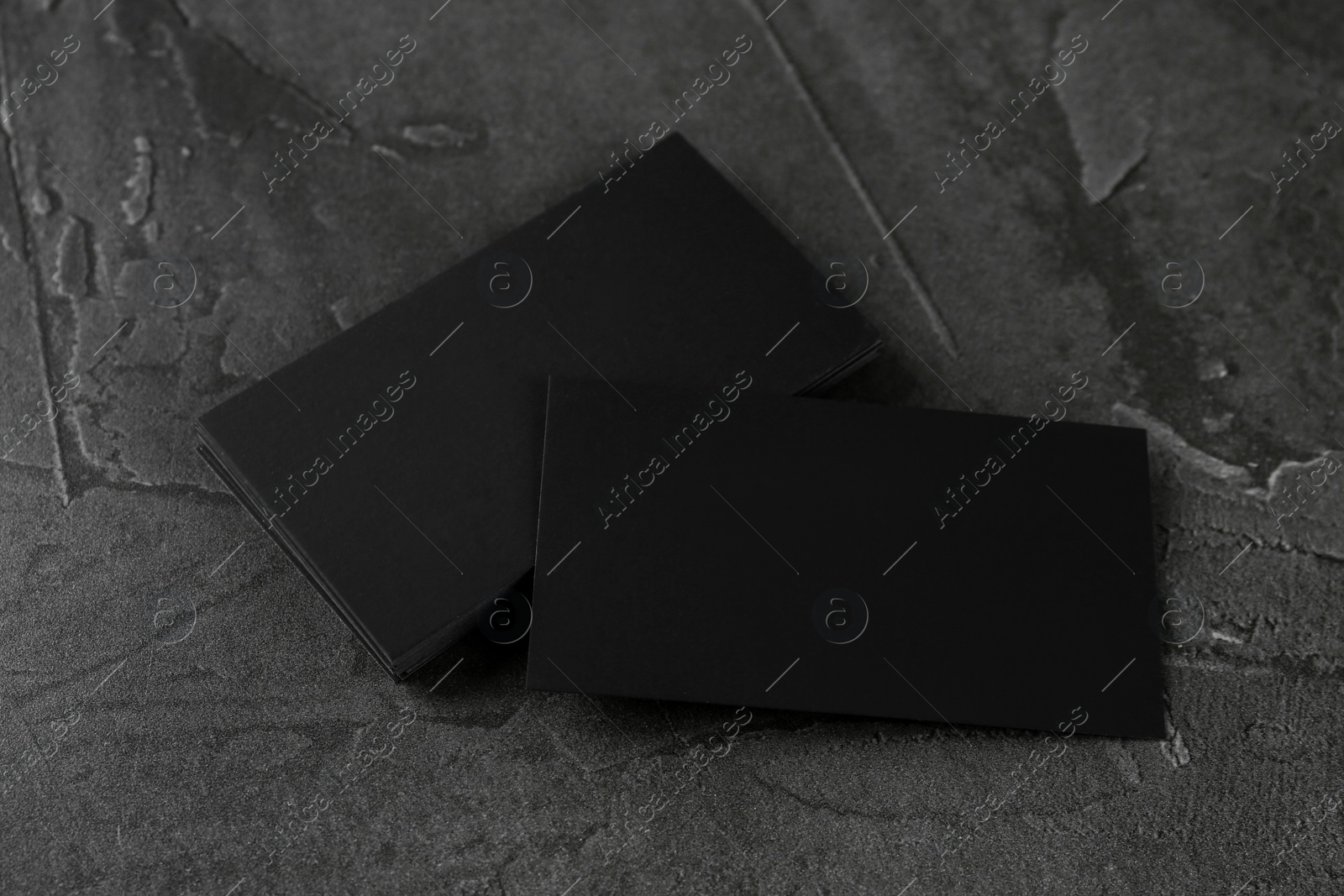 Photo of Blank black business cards on grey table. Mockup for design