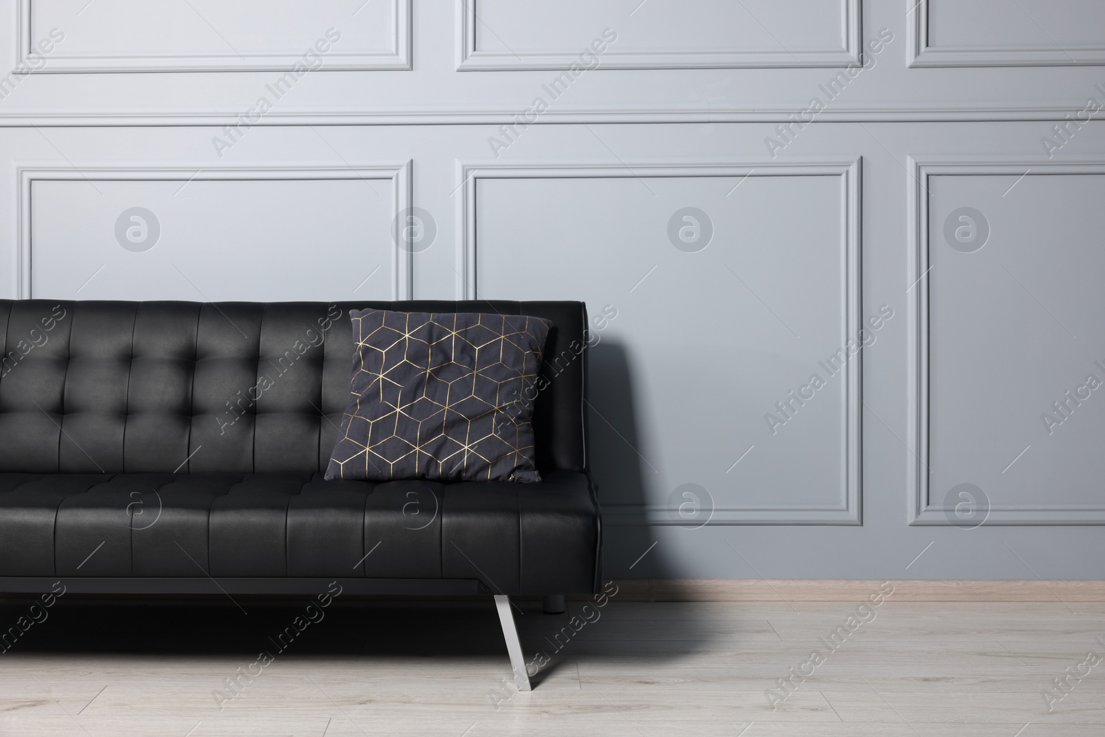 Photo of Stylish leather sofa near white wall in room. Interior design