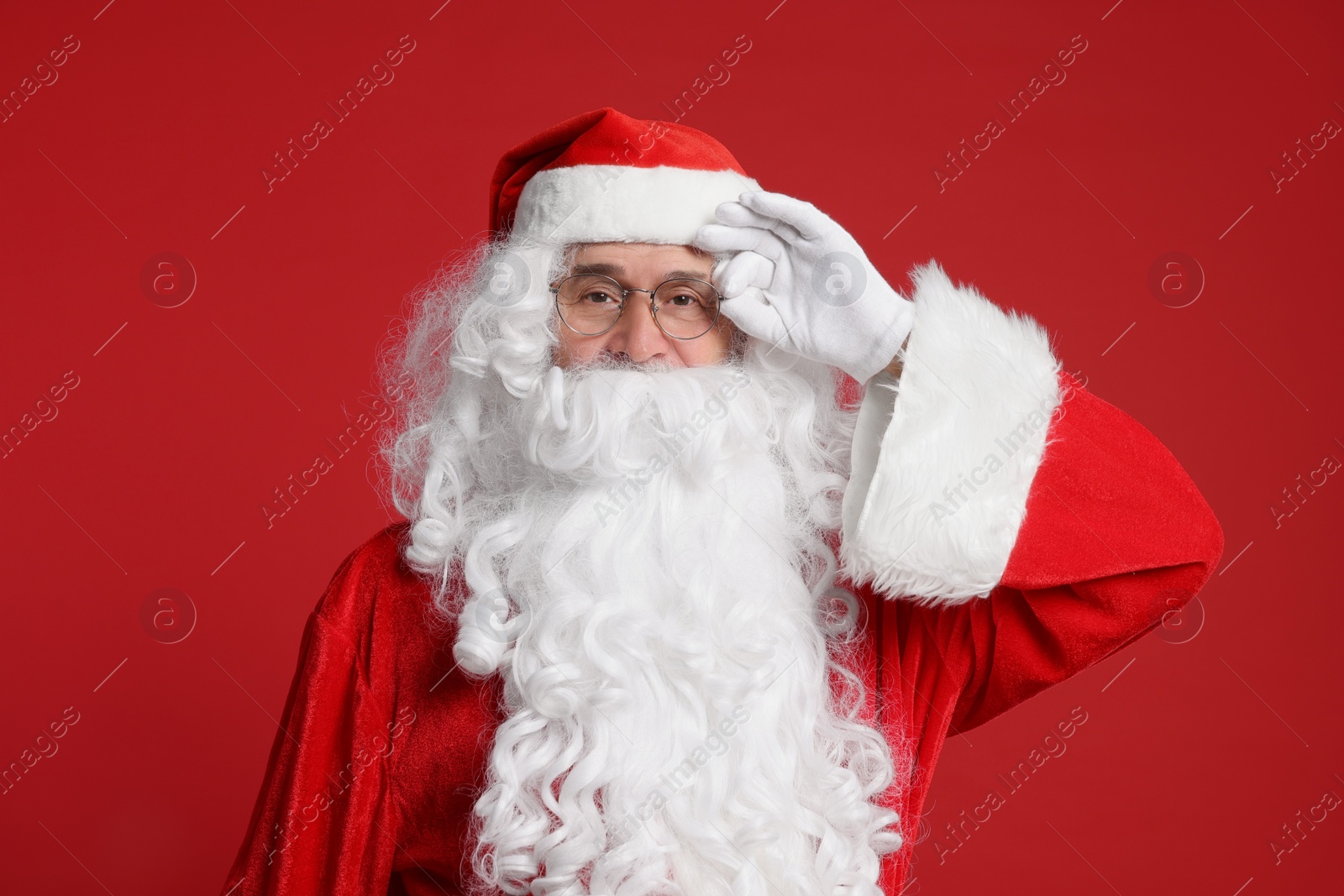 Photo of Merry Christmas. Santa Claus posing on red background