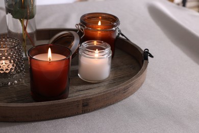 Tray with beautiful burning candles on table