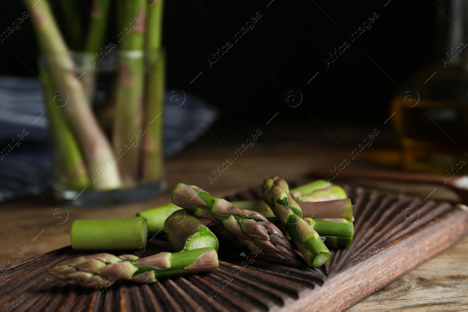 Photo of Fresh raw asparagus on wooden table, closeup