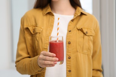 Woman with delicious smoothie indoors, closeup view